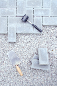 Hammer und Spachtel als Werkzeuge für das Pflastern der Terrasse